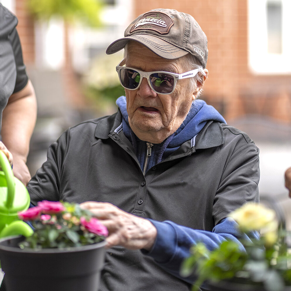 Resident enjoying a gardening activity outdoors as part of the recreational programs at Atrium Retirement Residence in Orillia